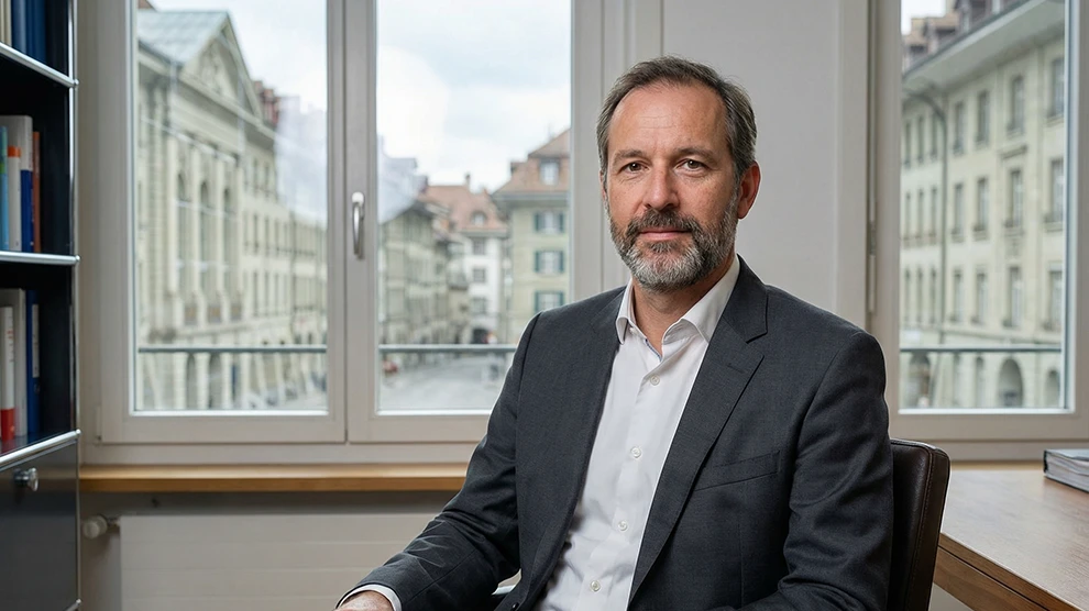 Mann im Anzug in modernem Büro mit Stadtblick — ideal für Jobs im Treuhand- und Finanzwesen in der Schweiz.