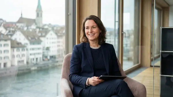 Frau im Büro mit Tablet, Blick auf Zürich, Jobs in Treuhand, Buchhaltung, Schweiz-Recruiting.